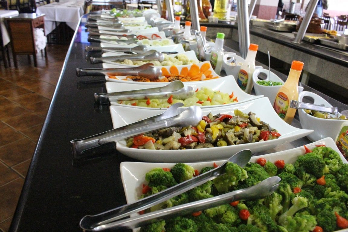 Balcão de saladas com travessas de legumes e conservas