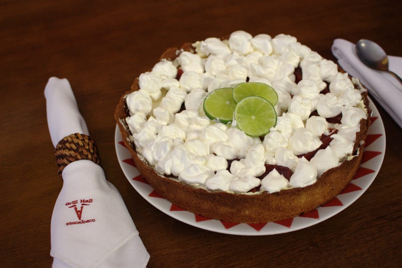 Torta de limão com merengue servida sobre mesa de madeira
